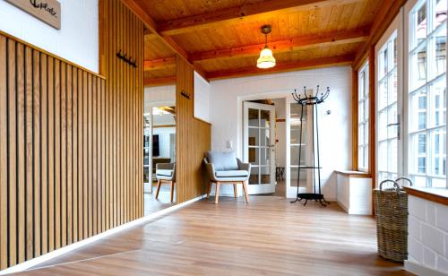a living room with a wooden ceiling and a chair at Ferienhaus Ankerplatz mit Sauna in Strandnähe in Reinberg