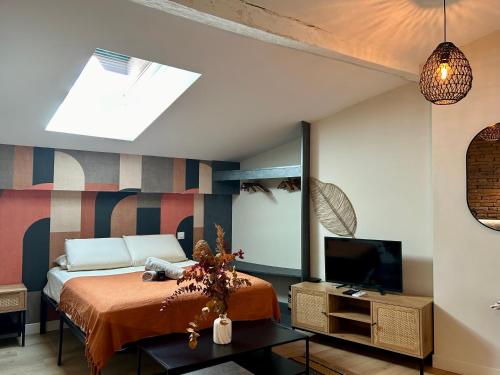 une chambre avec un lit et une télévision dans l'établissement Le Pantaléon - Sublime Studio Capitole, à Toulouse