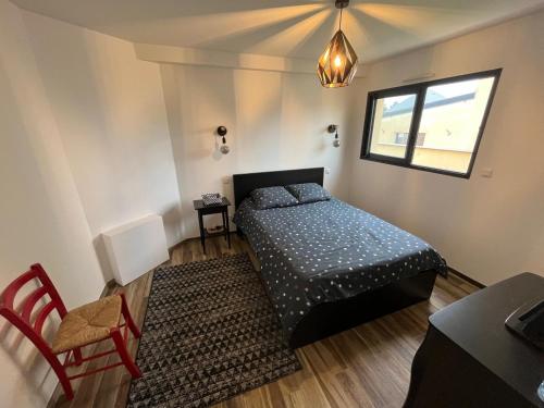 ein Schlafzimmer mit einem Bett und einem Tisch und einem Fenster in der Unterkunft Beach house in Gouville-sur-Mer