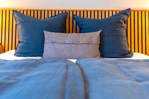 a bed with blue pillows and blue pillows at Ferienhaus Ankerplatz mit Sauna in Strandnähe in Reinberg
