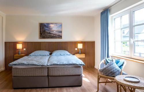 a bedroom with a bed and two windows at Ferienhaus Ankerplatz mit Sauna in Strandnähe in Reinberg