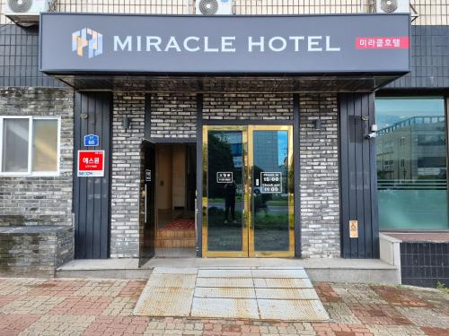 an entrance to a miracle hotel with the doors open at Jeju Miracle Hotel in Jeju