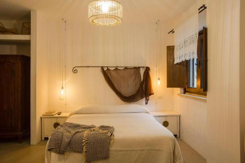 a bedroom with a bed and a chandelier at Casale Giancesare Villa Agricola in Capaccio-Paestum