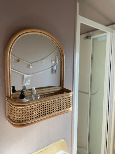 a mirror on the wall of a bathroom at Ecco Lodge Caravan in Leysdown-on-Sea