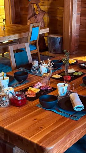a wooden table with plates of food on it at Sunday Morning Resort in Pyhätunturi