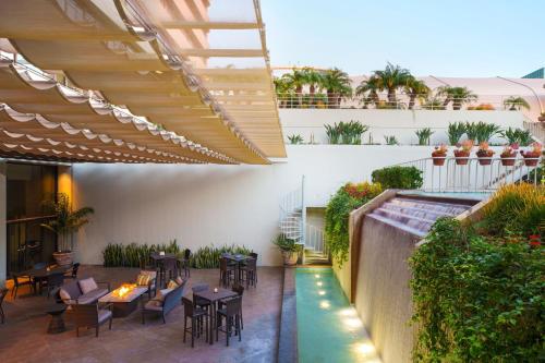 an outdoor patio with tables and chairs and a pool at The Westin South Coast Plaza, Costa Mesa in Costa Mesa