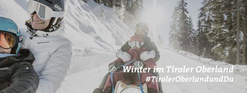 two people on a snowmobile in the snow at InnApartment Top 4 in Prutz