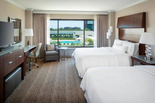 a hotel room with two beds and a desk at The Westin South Coast Plaza, Costa Mesa in Costa Mesa
