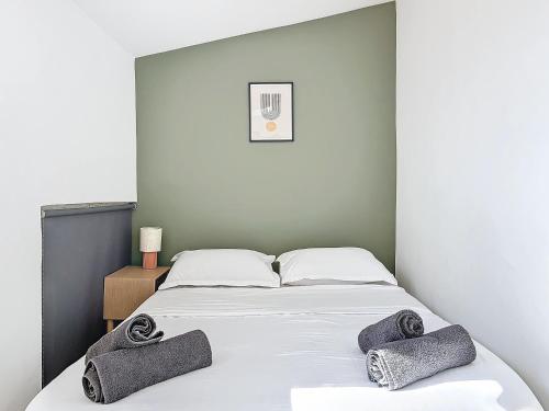 une chambre avec un lit avec deux serviettes dessus dans l'établissement Charmant appartement - Cours Julien - Central - Les Frères de la Loc', à Marseille