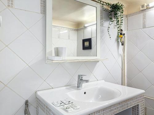 une salle de bain blanche avec un lavabo et un miroir dans l'établissement Charmant appartement - Cours Julien - Central - Les Frères de la Loc', à Marseille