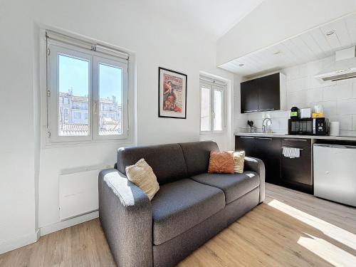 un salon avec un canapé et une cuisine dans l'établissement Charmant appartement - Cours Julien - Central - Les Frères de la Loc', à Marseille