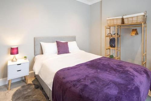 a bedroom with a large bed with a purple blanket at Hampton Manor House - 9 Bedrooms in St Bees