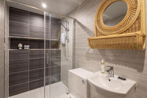 a bathroom with a sink and a shower and a mirror at Hampton Manor House - 9 Bedrooms in St Bees