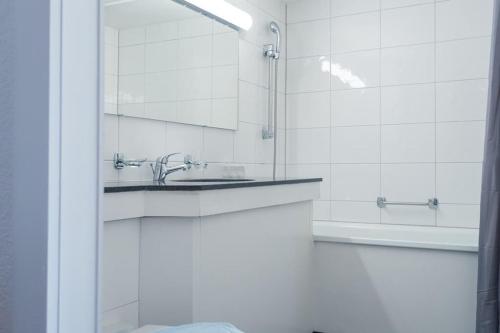 a bathroom with a sink and a mirror and a tub at HITrental Chapel Bridge Apartments in Luzern
