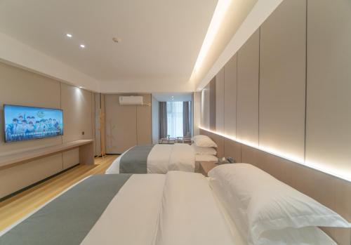 a hotel room with two beds and a flat screen tv at Lucky Praised Scenery Hotel in Zhangjiajie