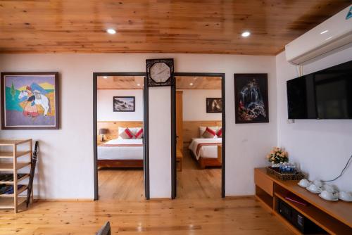 a living room with a clock and a bedroom at SaPa Retreat Condotel in Sa Pa