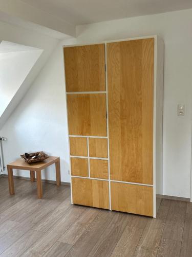 a large wooden cabinet in a room with a table at Ferienwohnungen Dörte & Stella Hof Saale in Hof