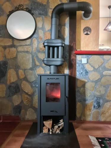 a wood fired stove in a room with a stone wall at Zlatiborsko Srce 2 in Zlatibor