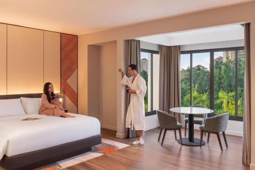 a man and a woman standing in a hotel room at Palm Garden Hotel, Putrajaya, a Tribute Portfolio Hotel in Putrajaya