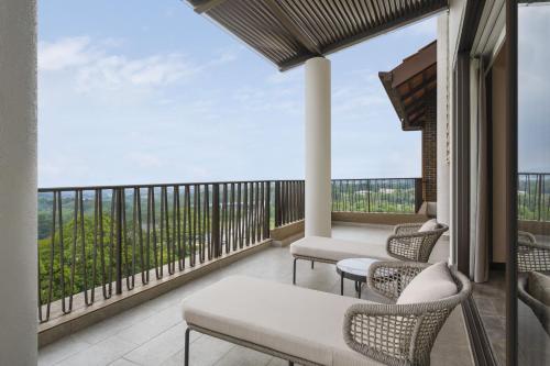 a balcony with chairs and a view of the ocean at Palm Garden Hotel, Putrajaya, a Tribute Portfolio Hotel in Putrajaya