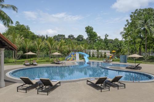 a pool with chairs and a slide at a resort at Palm Garden Hotel, Putrajaya, a Tribute Portfolio Hotel in Putrajaya