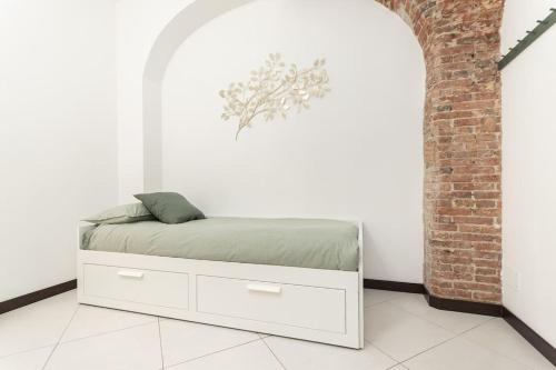 a white bed in a room with a brick wall at Casa Mary - 50 mt dal mare - centro storico in Varazze