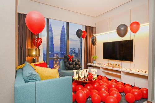 a living room with red balloons and a blue couch at Imperial KLCC by Opus Hospitality in Kuala Lumpur