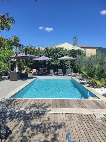 une piscine avec chaises et parasols dans l'établissement Maison avec Jardin et Piscine privée, à Nyons