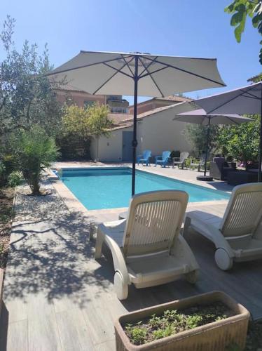 deux chaises et un parasol à côté d'une piscine dans l'établissement Maison avec Jardin et Piscine privée, à Nyons