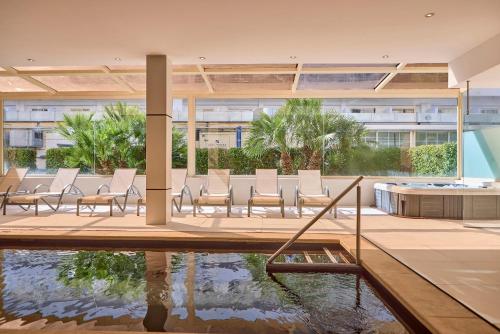 a group of chairs and a pool in a building at Zafiro Rey Don Jaime in Santa Ponsa