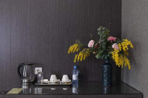 a table with a vase of flowers on it at Resident Hotel Kazybek Bi in Almaty