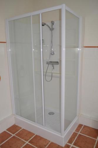 W łazience znajduje się prysznic ze szklanymi drzwiami. w obiekcie Les Bruyeres B&B w mieście Montbron