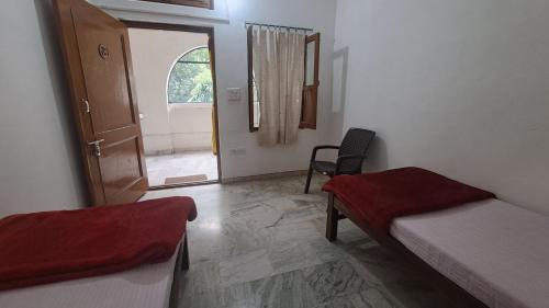 a room with two beds and a door with a window at Swami Samarpan Ashram in Rishīkesh