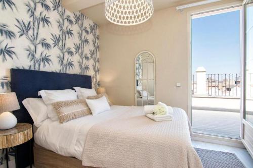 a bedroom with a large bed with a large window at Penthouse Lorena in Granada