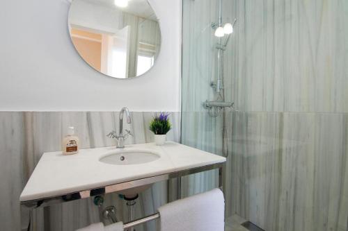 a bathroom with a sink and a shower with a mirror at Penthouse Lorena in Granada