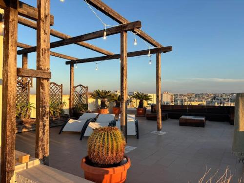 a patio with tables and a cactus on a roof at Tra cielo e mare in Giovinazzo
