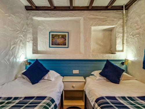 a bedroom with two beds with blue pillows at Clyne Farm Centre in The Mumbles