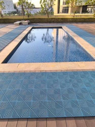 a swimming pool with blue tiles on the ground at Venus saadiyat beach apartment with SeaView in Abu Dhabi