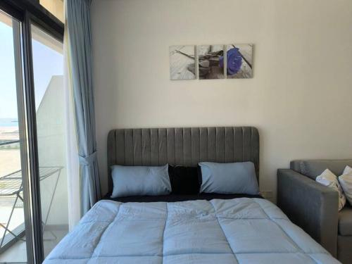 a bed with blue pillows in a room with a window at Venus saadiyat beach apartment with SeaView in Abu Dhabi