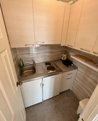 a small kitchen with a sink and white cabinets at Apartment Via in Brela