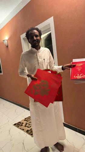 a man is holding up a red present at Karma Kono in Abu Simbel