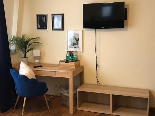 a room with a desk and a tv on a wall at Boutique-garni Hotel Papillon in Kempen