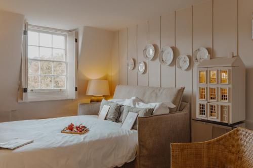a bedroom with a bed with a plate of fruit on it at No 15 by GuestHouse, Bath in Bath