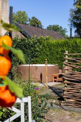 a garden with a wooden bench and a fence at De oude walnoot in Sint Pancras