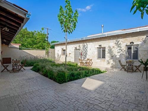 a patio with chairs and a tree next to a building at Andre Marie Stonewood Retreat in Limassol