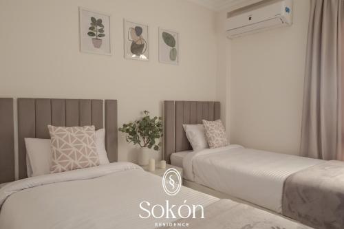 two beds sitting next to each other in a bedroom at Luxury 2BR City View Sokón R in Madinaty