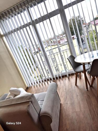 a living room with a couch and a table in front of a large window at Lazur Apartamenty in Świnoujście