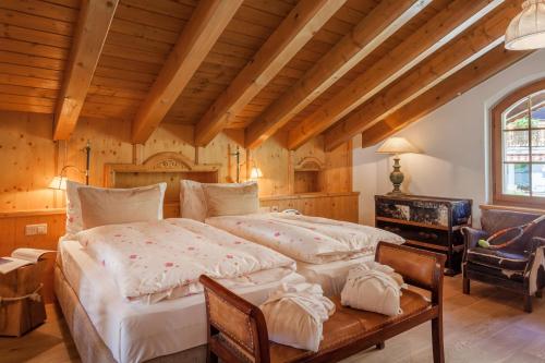 a large bedroom with a large bed and a desk at Hotel Berghof in Zermatt