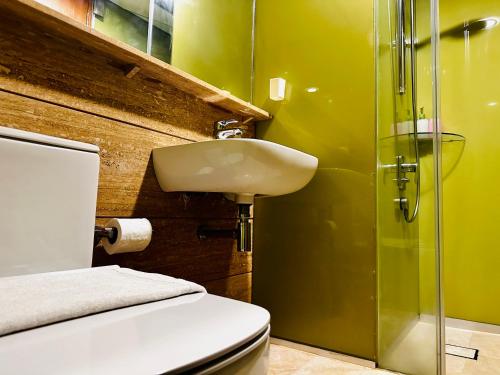 a bathroom with a toilet and a sink and a shower at Sky Suites KLCC BY Arman in Kuala Lumpur
