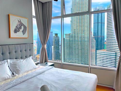 a bedroom with a bed and a large window at Sky Suites KLCC BY Arman in Kuala Lumpur